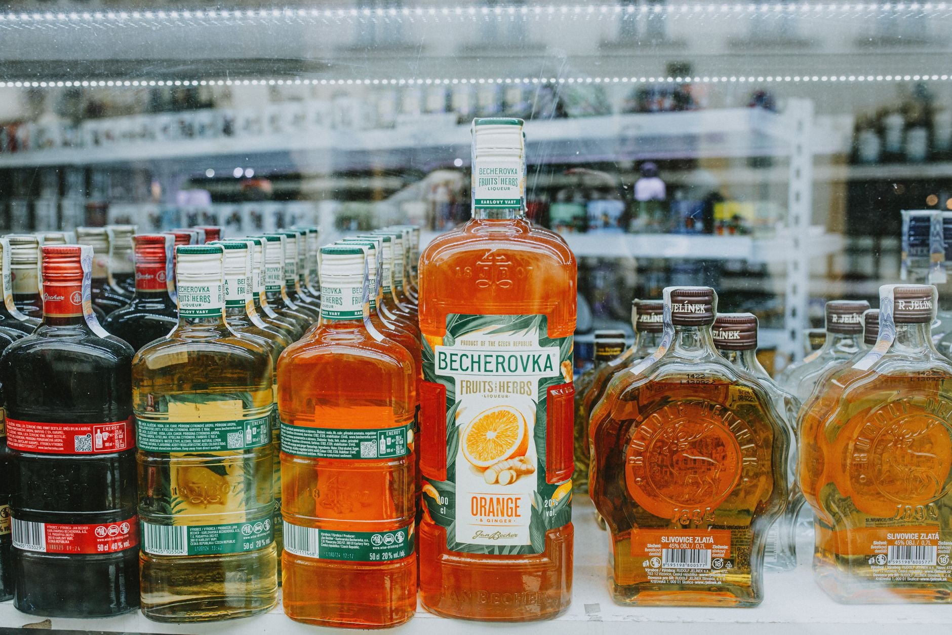 An array of vibrant liquor bottles displayed in a store showcase highlighting various spirits.